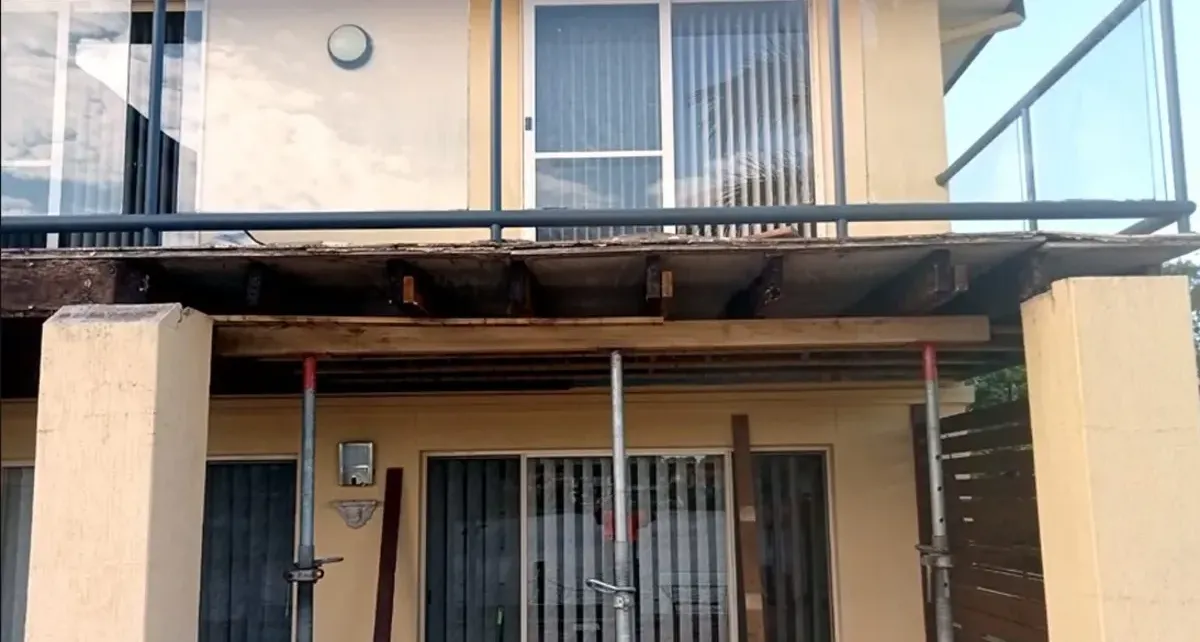 a balcony stripped back to bare bearers and propped on temporary supports