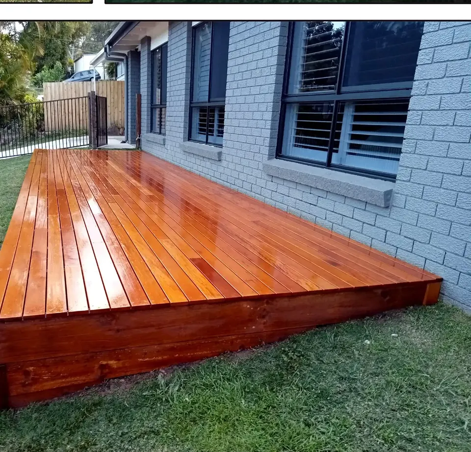 new hardwood deck freshly oiled beside a brick home