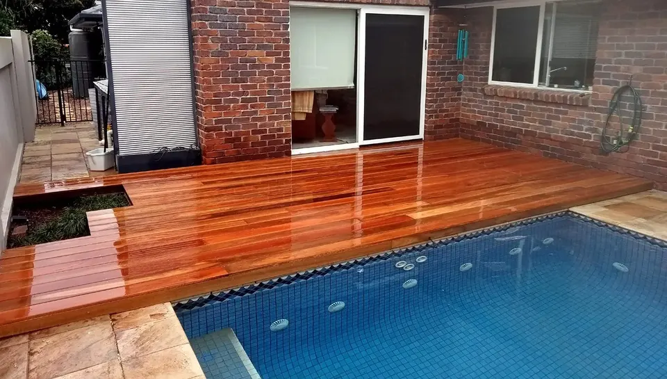 new hardwood deck built around a backyard pool